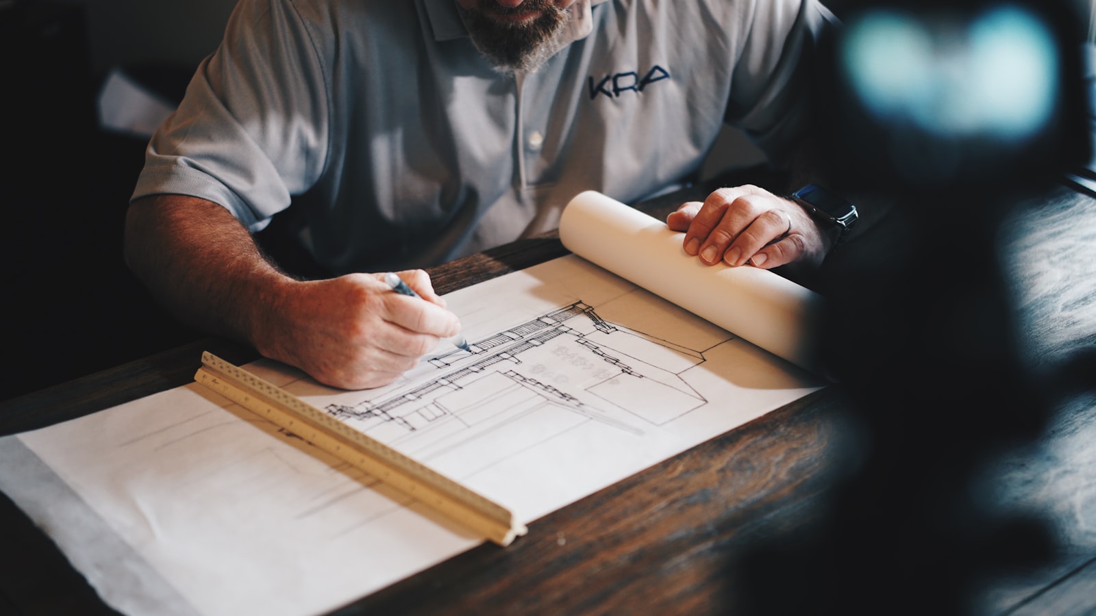 Architectural plans and drafting tools on a jobsite table